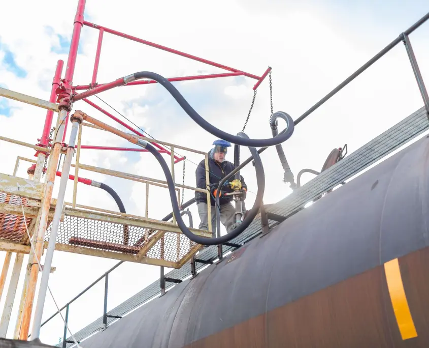 Employee on top of large storage tank in Tobyhanna yard