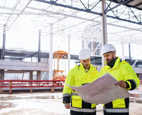 Engineers standing outdoors on a construction site with temporary heating