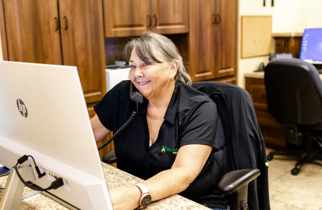 7F6A2833 Smiling employee on phone looking at computer monitor