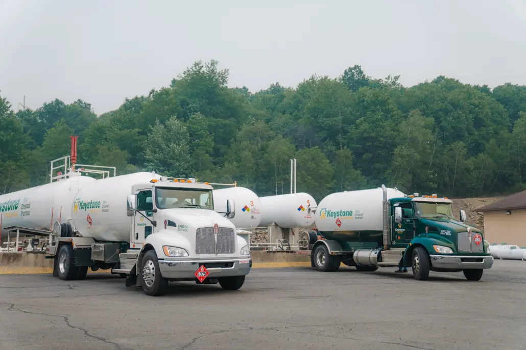 Keystone-142 2 Propane trucks parked in front of large storage tanks