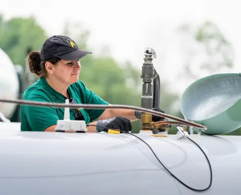 Employee filling large propane tank
