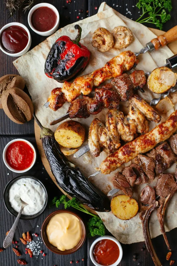 Various foods on skewers resting on picnic table