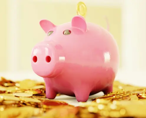 Pink piggy-bank standing on gold coins