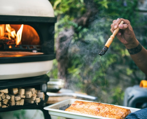 chef using gozney dome pizza oven to cook salmon