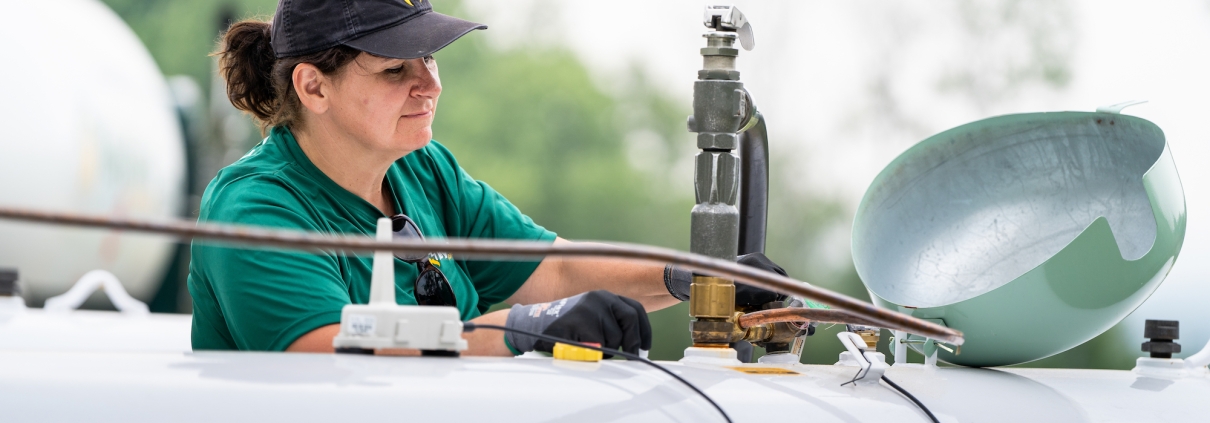 Employee filling large propane tank