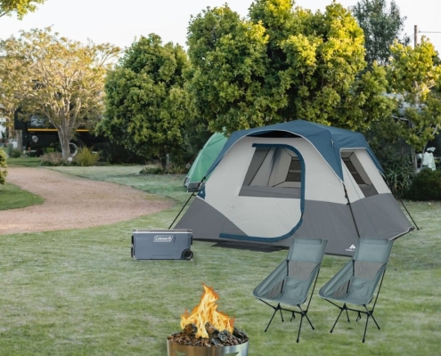 Campsite with tent, cooler, chairs, and firepit.