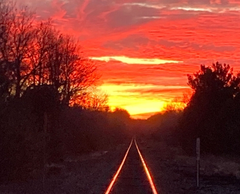 Train tracks at sunset reflecting the light