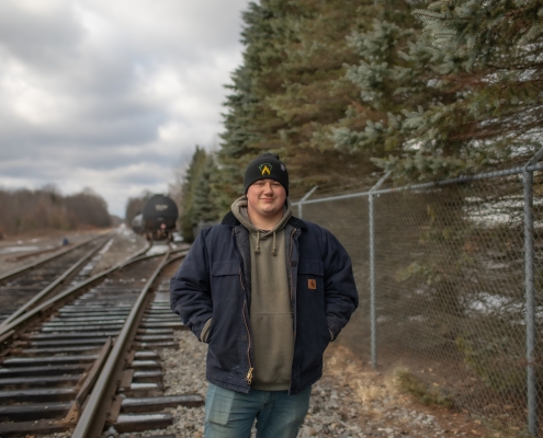 Employee standing in front of parked railcars