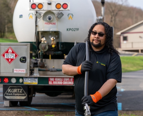 Employee pulling hose away from delivery truck