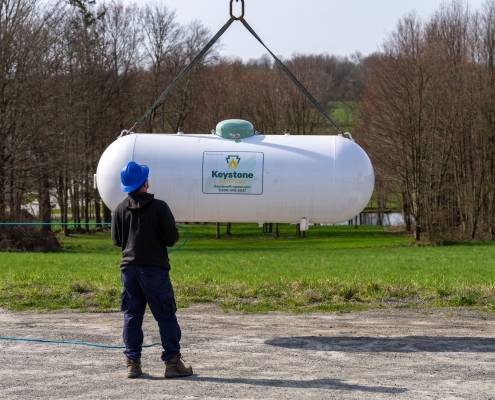 Employee using crane to move tank into place