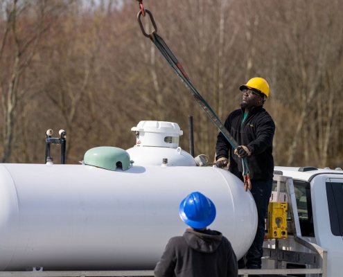 Hooking up crane to remove tank from truck