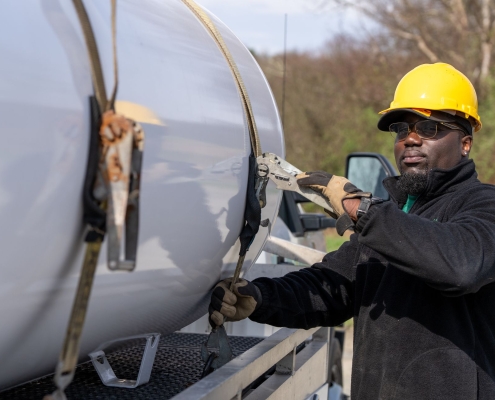 Removing straps from tank on vehicle