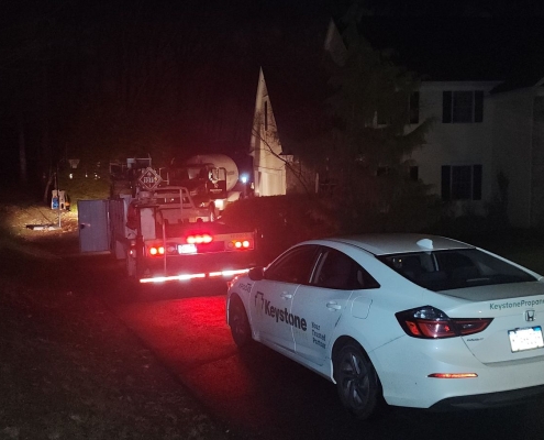 Rear of Keystone car and service vehicle parked at night