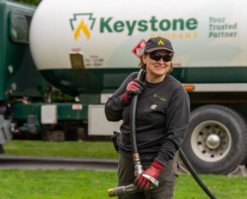 Employee holding hose and smiling for camera