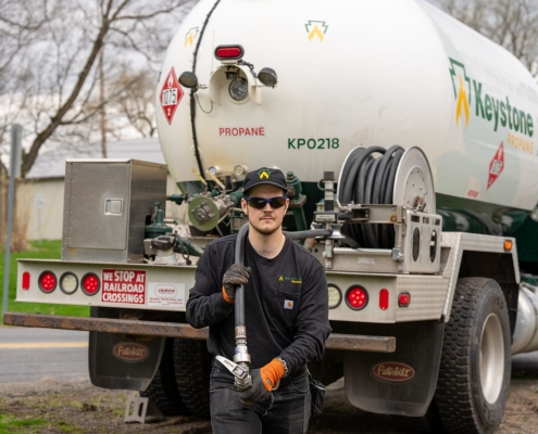 Employee dragging hose away from truck