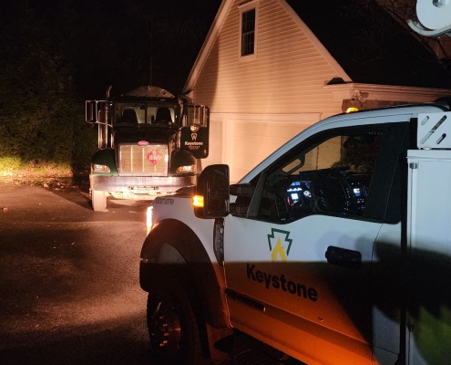 Side of Keystone service vehicle and front of bobtail parked at night