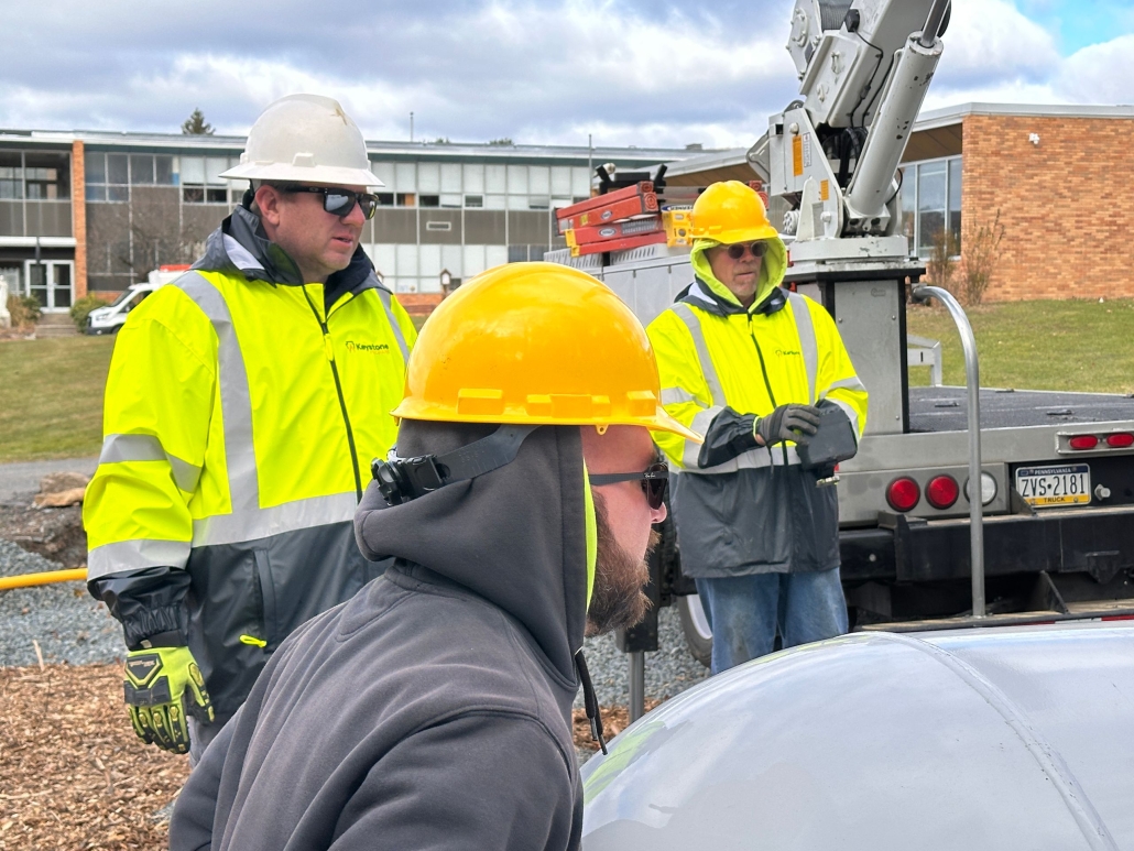 Employees maneuvering tank into place