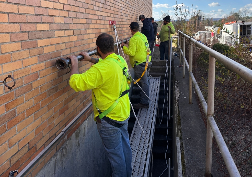 Crew on scaffolding installing pipe