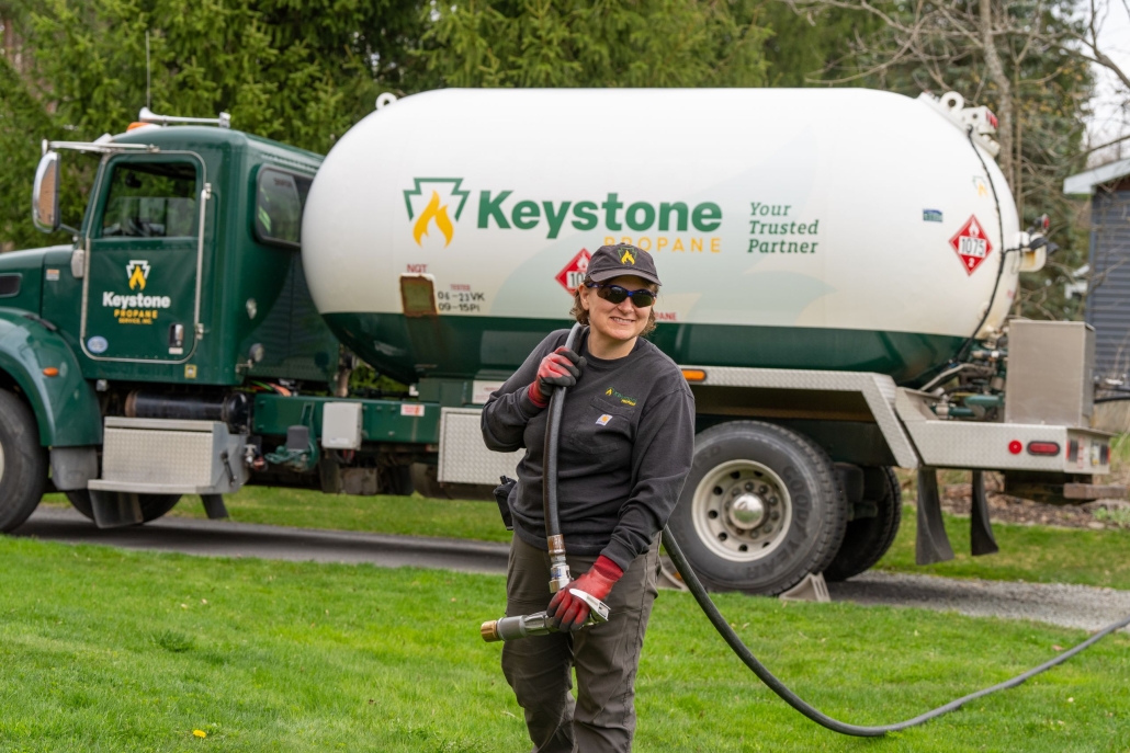 Employee pulling delivery hose across lawn