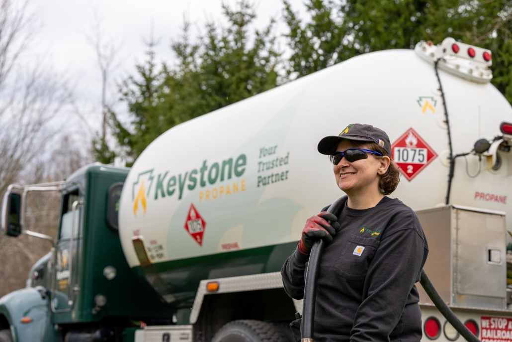 Driver standing with hose by Keystone truck