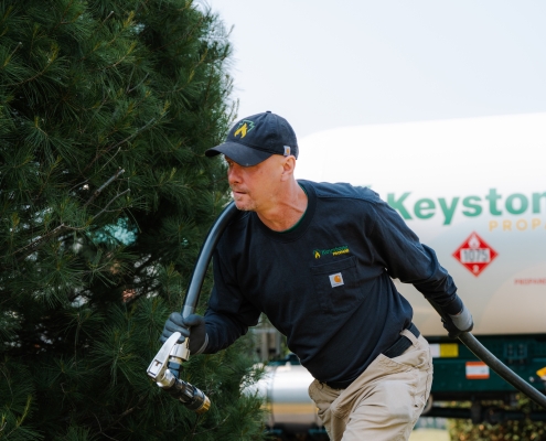 Employee dragging delivery hose