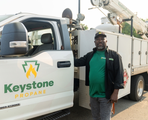 Employee standing next to service truck