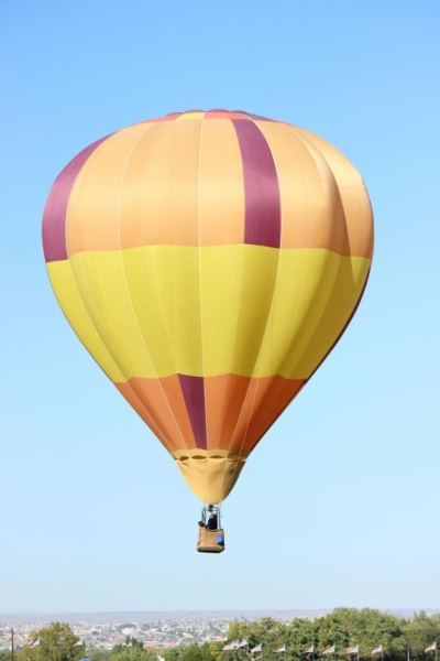 Hot air balloon flying with town below