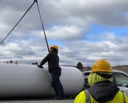 Employee beginning to lift tank off truck